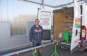 Cédric Potez avec une gouttière préparée “à la demande”, sortie de la machine que l’on aperçoit à l’arrière de son véhicule.