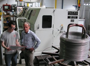 A côté de la presse transfert multiposte (déformation à froid, découpe, contrôle…) alimentée par des bobines de fils : Olivier Carnière, l’actuel dirigeant, et Mickaël Bouillon, régleur. 